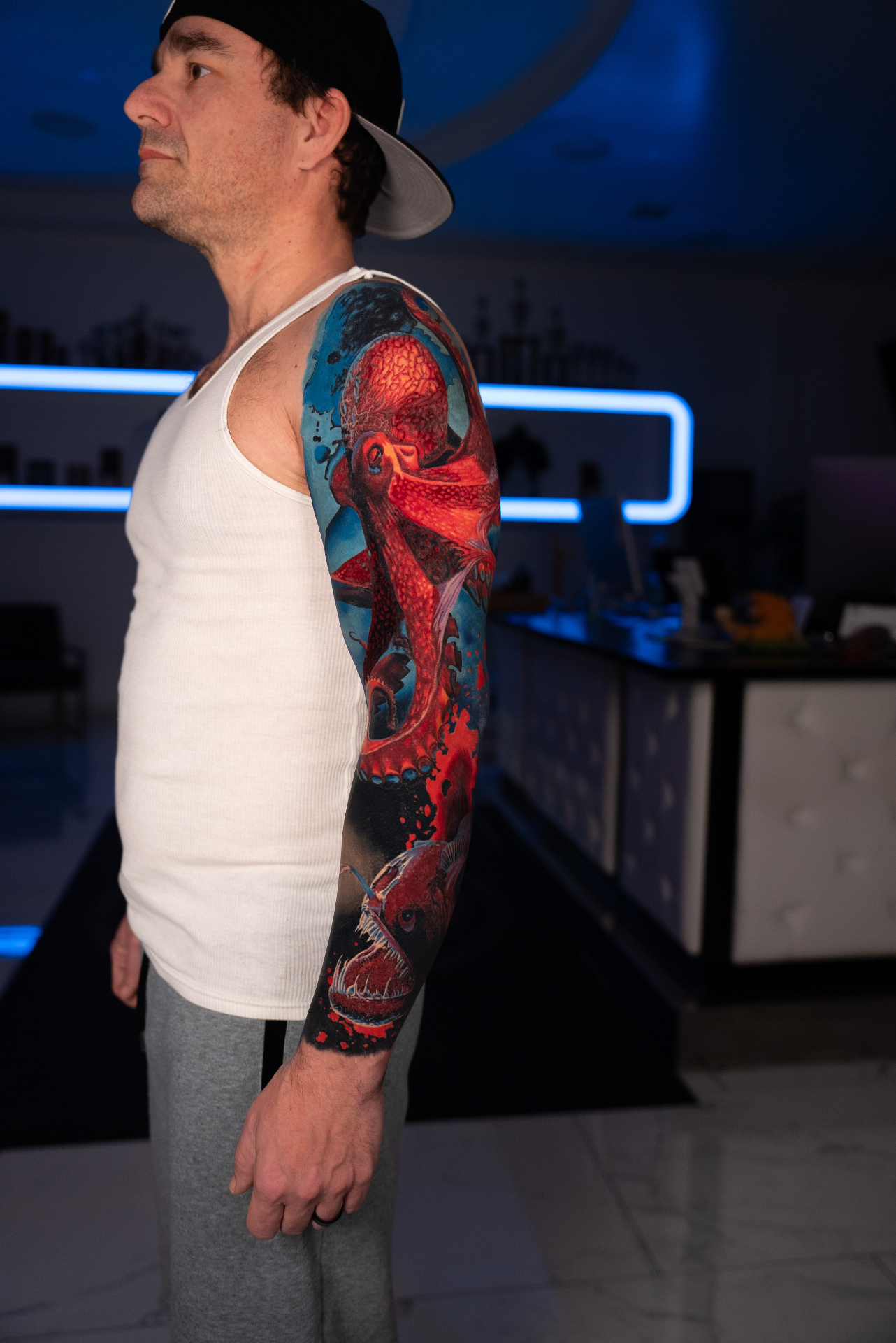 Colour full arm sleeve of a red octopus above a bioluminescent anglerfish
