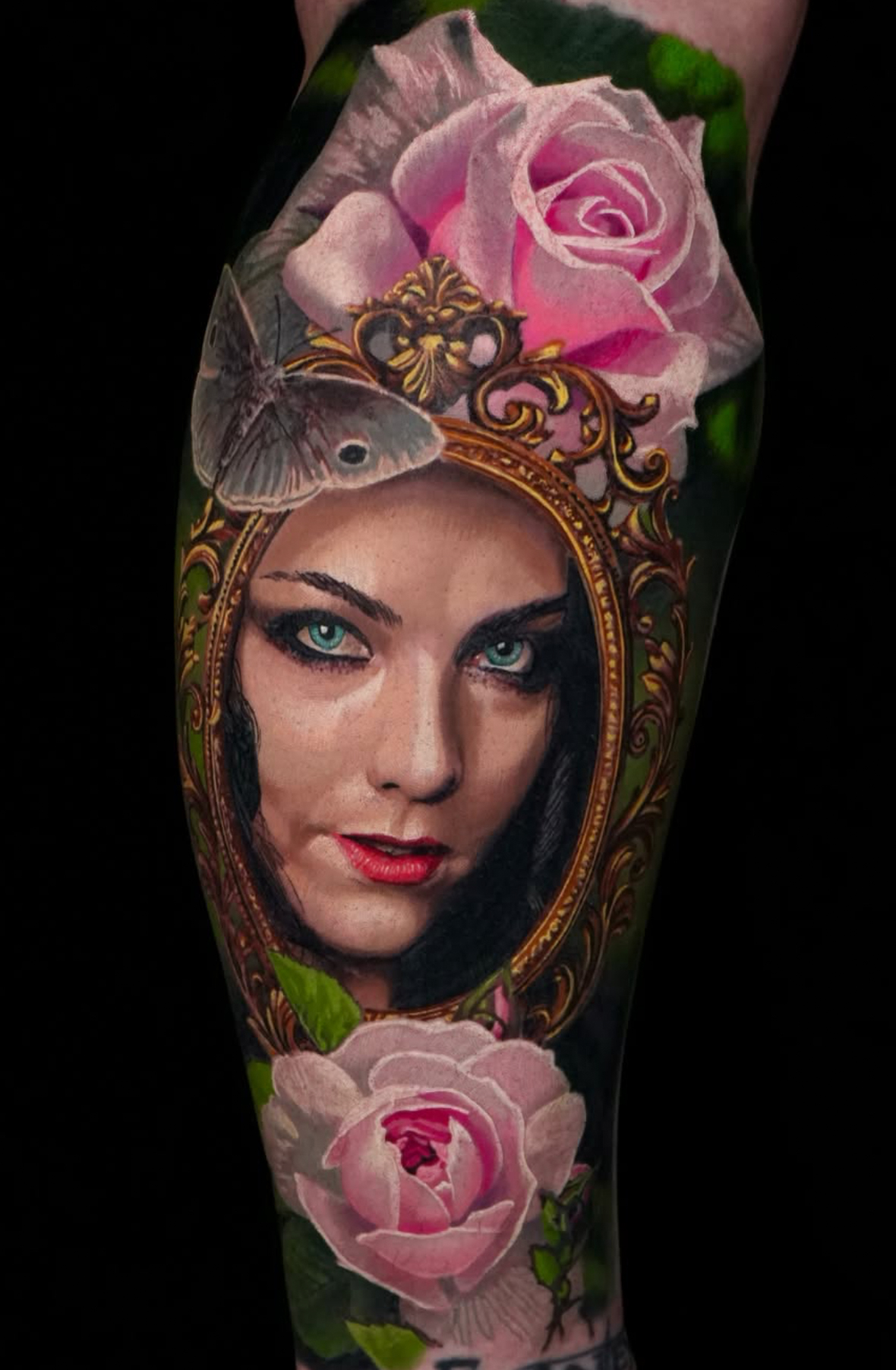Colour realism calf piece of a woman's face inside an ornate golden mirror framed by pink roses and a grey moth